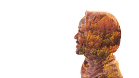 Autumn fashion. Eco silhouette. Environmental harmony. Double exposure profile portrait of relaxed smiling woman in headscarf with red yellow foliage isolated on white empty space.の写真素材