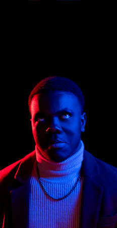 Annoyed man. Displeased emotion. Wrong choice. Magazine flyer. Irritated angry guy rolls eyes in bright neon light isolated on dark copy space background.の写真素材