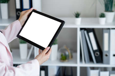 Digital work. Computer mockup. Online connection. Unrecognizable woman holding tablet computer with...
