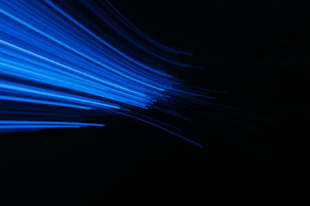 Blur neon light. Luminous rays. Cyber illumination. Defocused ultraviolet navy blue color laser beam flare motion on dark black futuristic abstract background.の写真素材