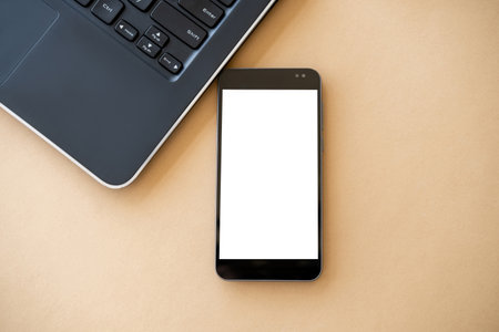 Mobile mockup. Online technology. Virtual life. Smartphone with white blank screen and opened laptop...