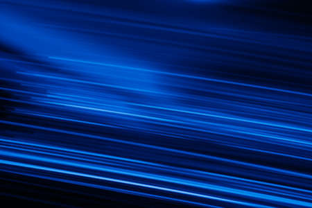 Blur neon glow. Luminous light flare. Cyber glare reflection. Defocused UV navy blue color streak rays motion on dark night black futuristic abstract background.の写真素材