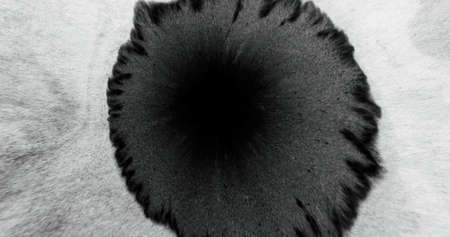 Black ink splatter texture. Paint splash. Frayed edge. Fluid blob on white grain paper rough...