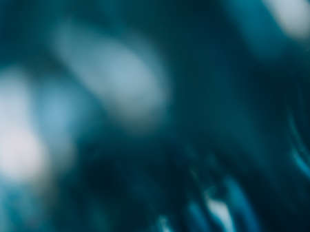 Defocused glow background. Light flare. Beam reflection. Blur white teal blue color smeared glare flecks on dark abstract copy space texture.の写真素材