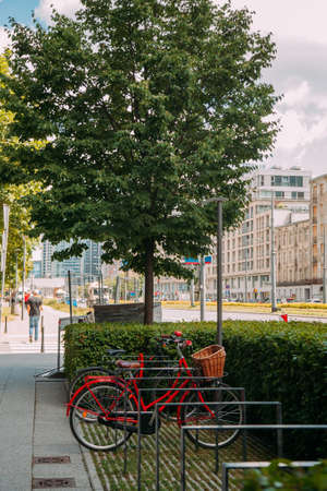 Rental service. Mobile transport. City vehicle. Several bikes with basket in parking zone on street daylight.の写真素材
