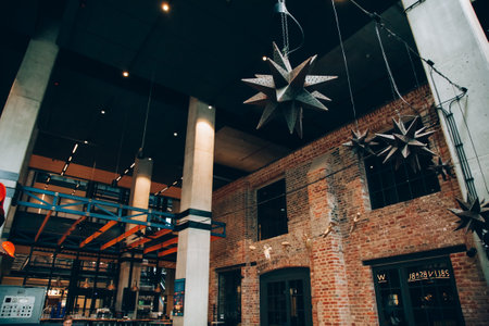 Warsaw, Poland - June 22, 2022: Creative cafe. European architecture. Grunge style. Modern buildings with visual bricks food court zone unusual hanging chandelier.のeditorial素材