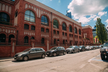 Warsaw, Poland - June 27, 2022: Historical museum. Tourist place. City architecture. Street road with red bricks building Warsaw Rising museum and parking cars.のeditorial素材