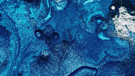 Fluid art. Abstract background. Glitter ink. Defocused sparkling silver white blue color bubble...