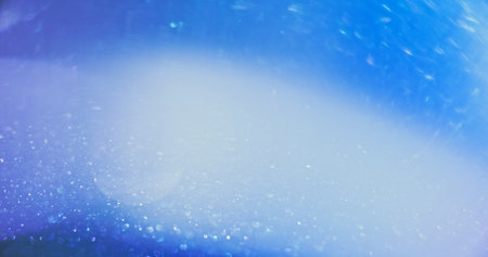 Defocused glow overlay. Bokeh light. Shimmering gleam. Blur white blue color lens flare shiny glitter texture abstract empty space background.の写真素材