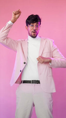 Excited man. Success celebration. Triumph joy. Pink color neon light happy enthusiastic amused winner guy in glasses suit dancing.の写真素材