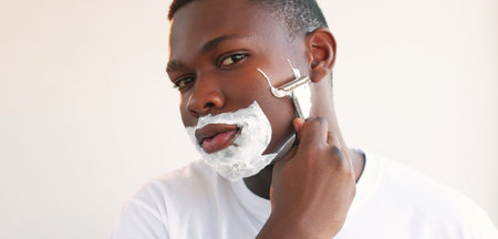 Face shaving. Skin care. Morning grooming. Closeup portrait of confident man with white foam cream...