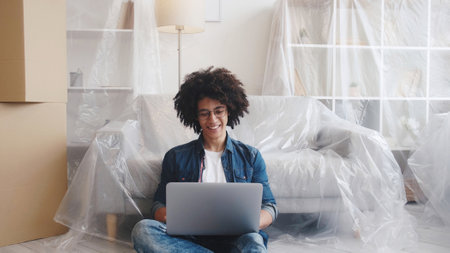 Online mortgage. Home relocation. Real estate. Happy smiling guy searching for new flat using laptop...