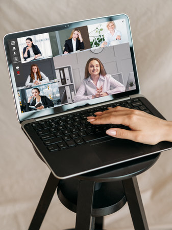 Web conference. Online briefing. Corporate telecommuting. Female leader watching business team working discussing project on laptop screen.の写真素材