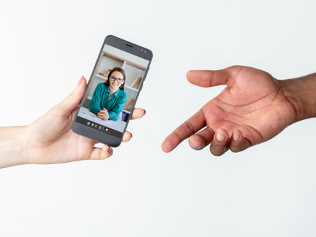 Online support. Video consulting. Distant interview. Diverse hands sharing phone with smart woman on screen isolated on white.の写真素材