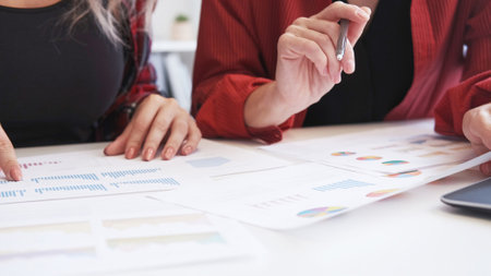 Market analysis. Business report. Financial statistics review. Unrecognizable female team discussing strategy working with charts graphs.の写真素材