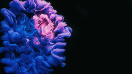 Fluid drop. Paint water. Explosion puff. Bright pink blue purple color ink smoke cloud floating on dark black abstract art empty space background.の写真素材