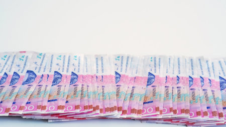 Cash money. Ukrainian hryvnia. UAH currency. Closeup of 200 hrn bill pink blue color paper banknotes pile on white empty space background.の写真素材