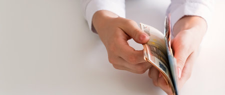 Money savings. Financial income. Budget economy. Closeup of business woman hands holding Euro cash paper banknotes on white empty space background.の写真素材