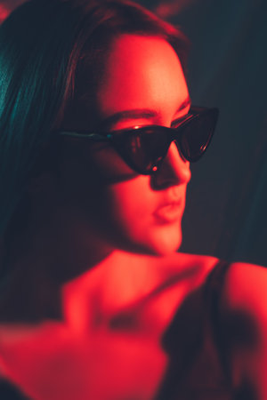 Eyewear fashion. Art portrait. Optical accessories. Red color light defocused woman face wearing...