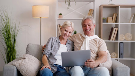 Online conference. Happy parents. Family contacts. Smiling middle-aged man and woman having video...