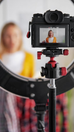 Online fashion stream. Stylist blog. Woman influencer recording video vlog on camera tripod ring...