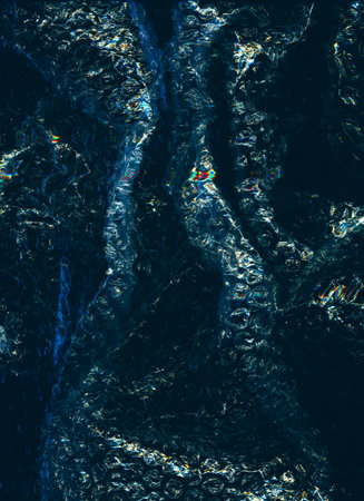 Creased overlay. Bubble plastic wrap texture. Grunge effect. Blue orange black color wrinkled distressed plastic film on dark illustration abstract background.の写真素材