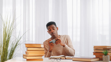 Gadget addiction. Phone distraction. Learning break. Irresponsible lazy young man student playing...