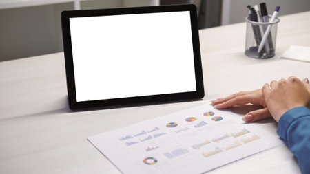 Online meeting. Data analysis. Video call. Business woman expert hands with graphs papers at digital tablet with empty space white mockup screen at home office.の写真素材