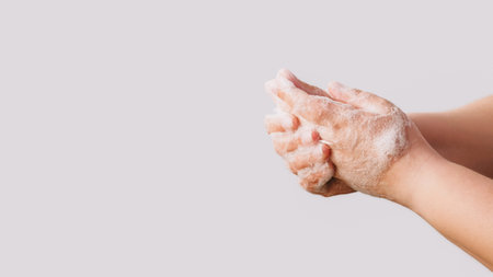 Hand hygiene. Infection prevention. Woman washing rubbing cleansing palms fingers skin with soap foam getting rid of bacteria isolated on white background empty space.の写真素材