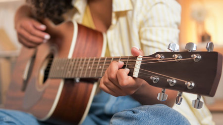 Guitar music. Artist playing. Closeup of fretboard singing woman learning song melody on acoustic string instrument indoors.の写真素材