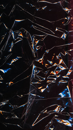 Grunge texture. Old film. Abstract background. Wrinkled black paper with yellow blue neon glowing glitch pattern on dark light shadow.の写真素材