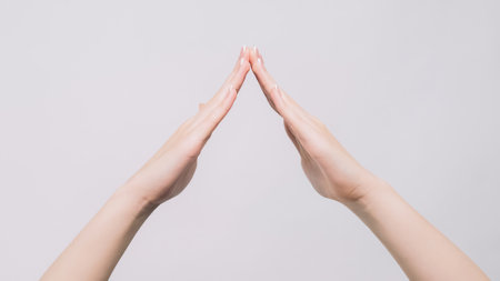 Home gesture. Roof symbol. Woman hands demonstrating housetop safe protection feeling isolated on gray free space background.の写真素材