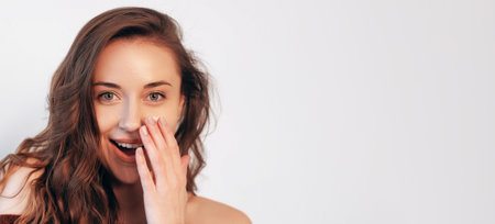 Amazement gesture. Advertising surprise. Discount novelty. Shocked pretty woman with natural makeup perfect face skin hand to open mouth isolated on white empty space.の写真素材