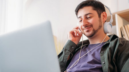 Music gadget. Song enjoyment. Device leisure. Joyful smiling carefree man listening mp3 tune...