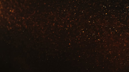 Sparks texture. Fire ash. Grain overlay. Blur orange red color burning dust particles flying on dark black copy space abstract background.の写真素材