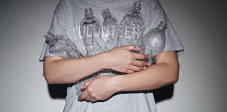 Waste collection. Plastic recycling. Environmental protection. Volunteer woman in t-shirt used...