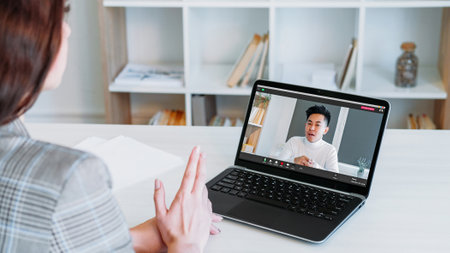 Video call. Web communication. Digital conference. Confident CEO business man speaking on laptop screen to employee woman at virtual office workplace.の写真素材