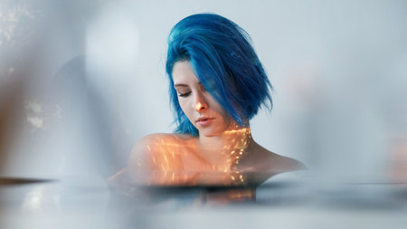 Beauty relaxation. Inner purity. Gentle creative woman tender individuality facial warm lights flickering blur reflections light background.の写真素材