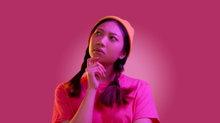 Pensive woman. Think solution. Pink color neon light doubting millennial vivid female pigtails make...