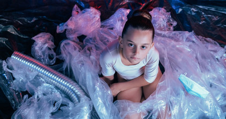 Plastic waste. Environmental change. Unhappy calm girl looking with judgment disposing medical mask...