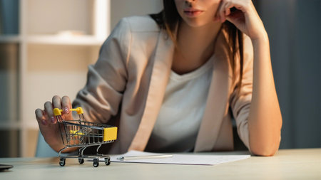 Lazy employee. Shopping daydream. Unhappy bored female office worker procrastinating playing toy delivery cart at workplace wishing purchase.の写真素材