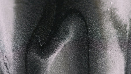 Silver glitter. Metallic texture. Blur gray black color spilling brilliance particles luxury fluid wet ink flow abstract art background.の写真素材