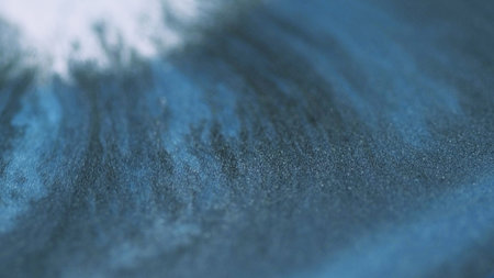 Shimmering glitter flow background. Sparkling blue emulsion mixes white shiny particles texture liquid paint wave fluid art.の写真素材