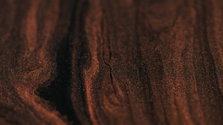 Glitter ink. Paint flow glow fluid. Defocused bronze brown black color shimmering brilliant texture mix particles moving abstract background.の写真素材