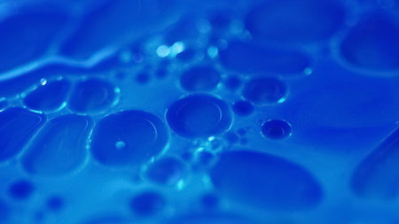 Bubble fluid. Ink drop water. Oil paint. Defocused blue color shampoo liquid gel emulsion foaming...