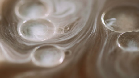 Sparkling paint. Oil drops. Defocused golden brown color spill brilliance liquid floating shiny bubbles luxury glowing gel abstract art background.の写真素材