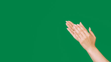 Applauding hands. Bravo greeting. Praise admiration. Success congrats. Proud woman clapping isolated on green empty space background.の写真素材