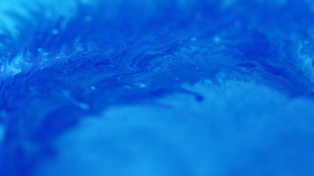 Paint splash. Fluid spill. Defocused blue color emulsion texture acrylic liquid mix wave flow abstract art background.の写真素材