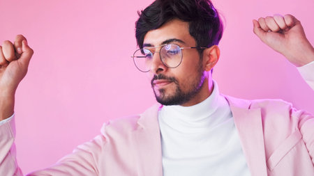 Winner dance. Victory inspiration. Neon light relaxed satisfied business man in glasses suit celebrating success isolated on pink copy space background.の写真素材