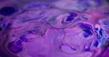 Glitter ink splash. Neon fluid. Defocused purple blue color shiny sparkling texture paint mix flow on black fantasy abstract art background.の写真素材